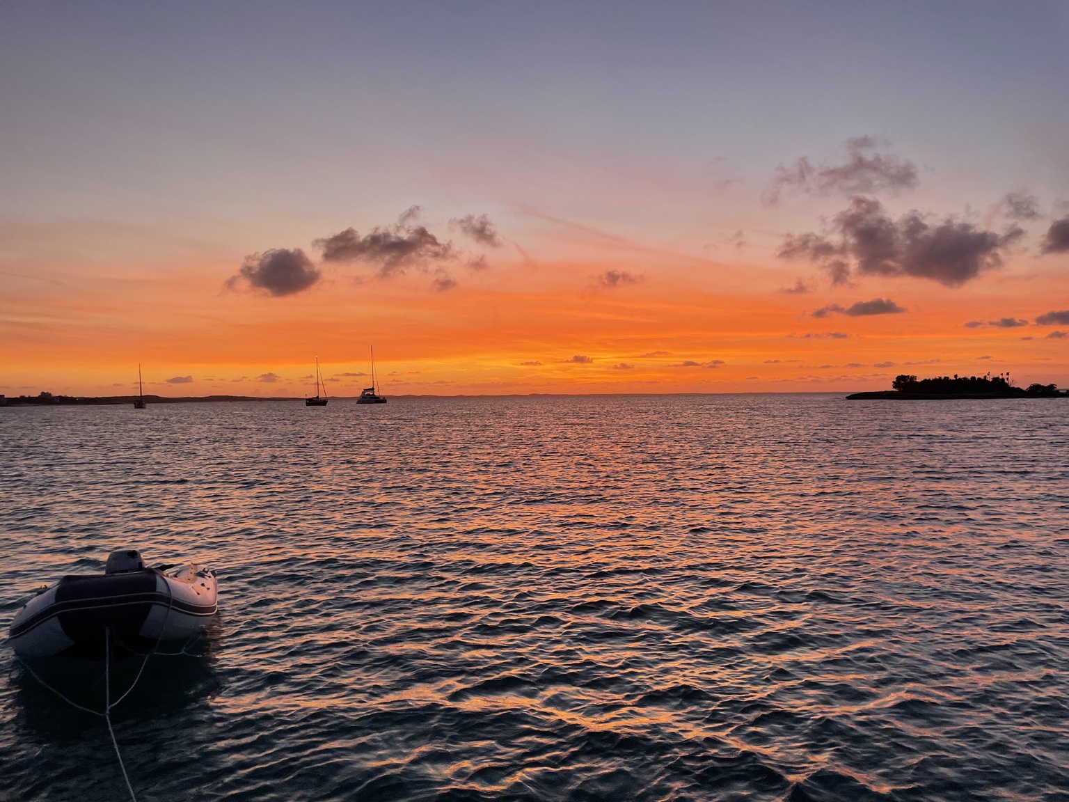 Bright orange sunset over anchored boats