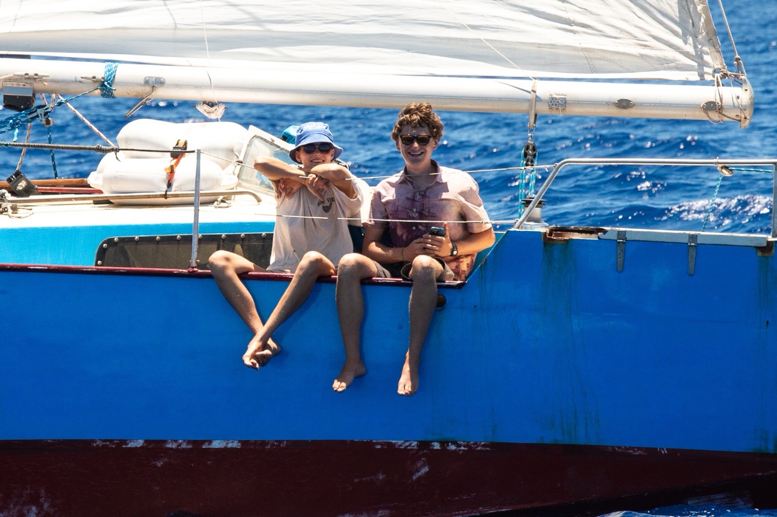 Captain Damian and girlfriend sitting on the side of the boat under sail